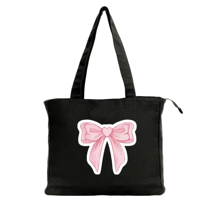 Black tote bag with a pink bow design on a white background